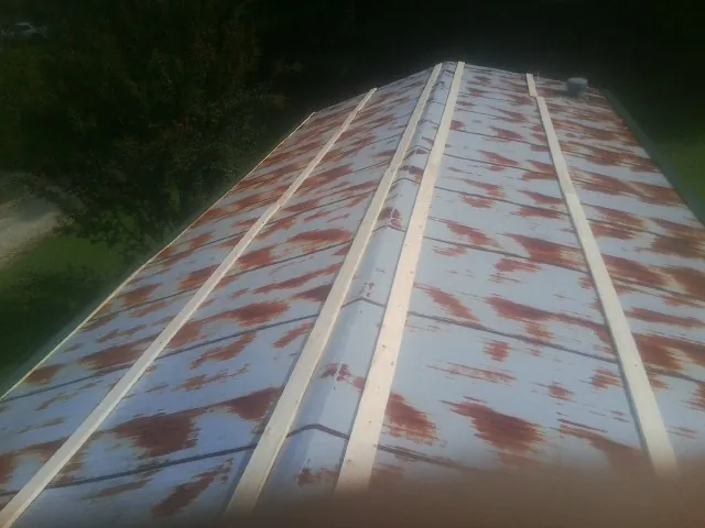 Rusted metal roof panels with new wood purlins before replacement — Storm Damage Roof Repair in Gulf by Roofing Brothers
