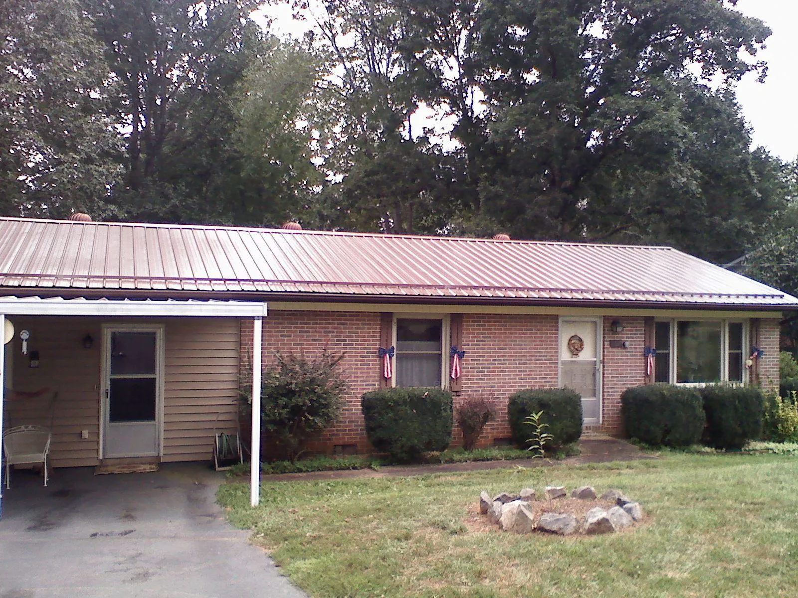 Bronze metal roof and carport on a brick ranch home — Roof Repair work by our crew in Gulf
